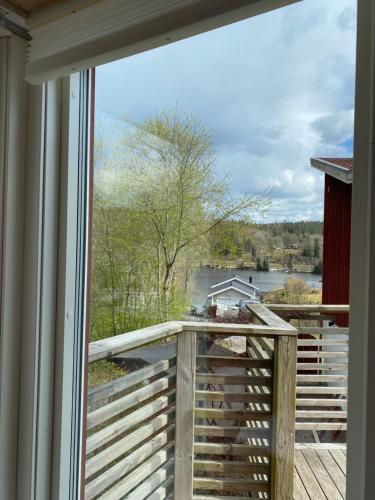 ein Fenster mit Blick auf eine Terrasse mit Blick auf das Wasser in der Unterkunft Sigridsro in Alingsås