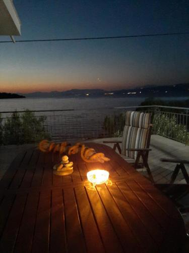 a wooden table with a fire on a deck with a chair at ARTE MARE d'Irene in Spárton