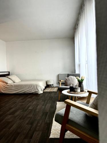 ein Schlafzimmer mit einem Bett, einem Sofa und einem Tisch in der Unterkunft Appartement confort in Vanves
