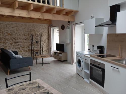 une cuisine et un salon avec laveuse et sécheuse dans l'établissement L'évidence 4 personnes, à La Jaudonnière