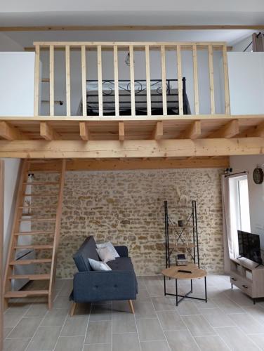 un salon avec un lit mezzanine et un canapé dans l'établissement L'évidence 4 personnes, à La Jaudonnière