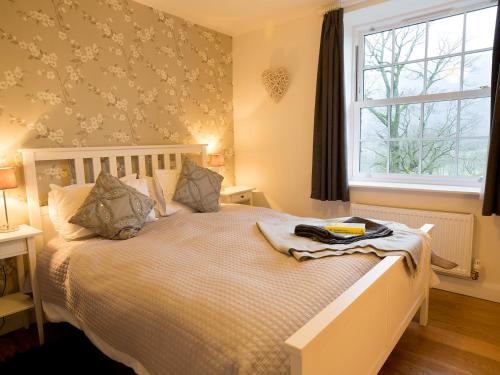 um quarto com uma cama com um cobertor e uma janela em 4 Fir Garth em Ambleside