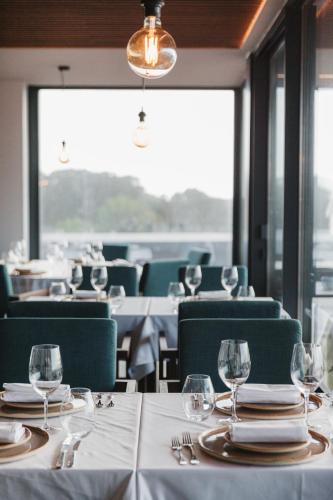 a dining room with tables and chairs with wine glasses at Pico Terramar & SPA in Areia Larga