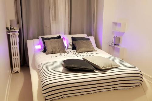 - un lit avec des draps et des oreillers en noir et blanc rayés dans l'établissement Quartier des emailleurs-T4 avec balcon et garage, à Limoges