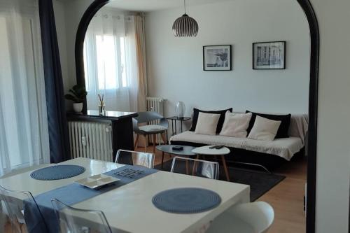 un salon avec un canapé, une table et des chaises dans l'établissement Quartier des emailleurs-T4 avec balcon et garage, à Limoges
