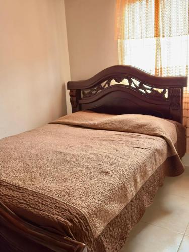 a bed with a wooden headboard in a bedroom at Habitación- valledupar cesar in Valledupar