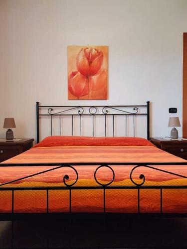 a bedroom with a bed with an orange bedspread at la casa di simone in Torre Tre Ponti