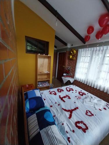 um quarto com uma cama com bombons vermelhos em Hotel Rural Café del Río em La Paz
