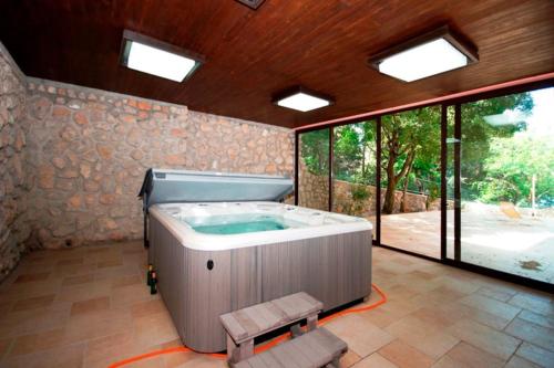ein großes Bad mit Whirlpool in einem Zimmer mit Fenstern in der Unterkunft Hotel Villa Lastura in Klenovica
