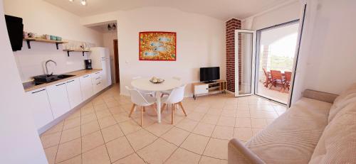 een woonkamer met een tafel en een keuken met een bank bij Apartments Luma in Hvar