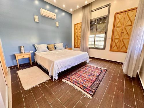 Al Matlīn的住宿－Du côté de chez Blili's，一间卧室配有一张大床和地毯。