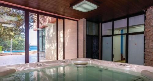 eine Badewanne in einem Zimmer mit einem großen Fenster in der Unterkunft Hotel Villa Lastura in Klenovica