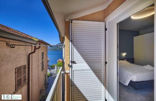 1 dormitorio con vistas al océano desde el balcón en Casa Posta, en Varenna