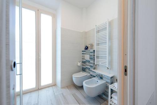 a bathroom with a toilet and a sink and a window at La Retara Affittacamere in San Benedetto del Tronto