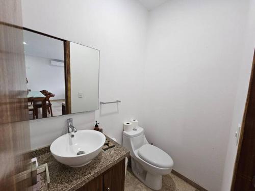 Un baño con lavabo, inodoro y espejo. en Villa 90 B Nayar, en Cruz de Huanacaxtle
