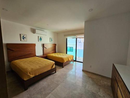 Una habitación de hotel con dos camas y balcón. en Villa 90 B Nayar, en Cruz de Huanacaxtle