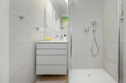 a white bathroom with a shower and a sink at HS Apartamenty Hevenia Heaven widok na morze in Rewal