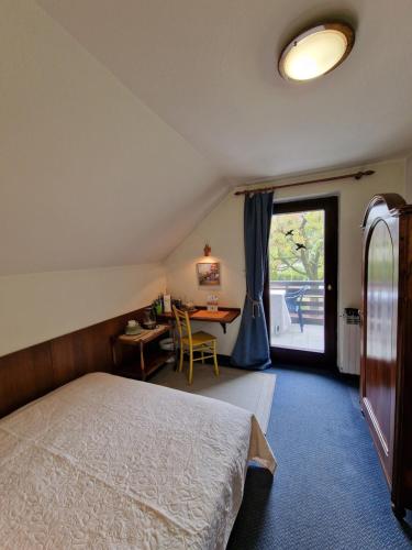 a bedroom with a bed and a table and a window at Vila Nana Bled Apartments & Rooms in Bled