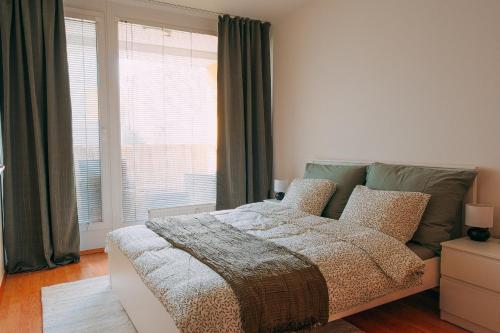 a bedroom with a bed and a large window at Apartmán u METRA, 4 hosté, parking free, blízko O2 arena in Prague