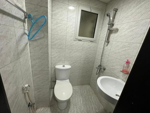 a bathroom with a toilet and a sink at Holiday Home Feel Like Home in Manama