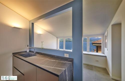 a kitchen with a sink and a large window at Casa Posta in Varenna