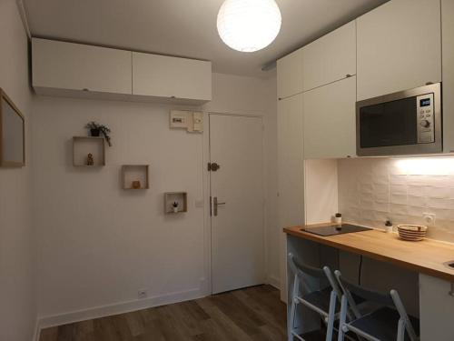 - une cuisine avec des placards blancs, un comptoir et un évier dans l'établissement Studio à 35 min du cœur de Paris, à Saint-Cloud