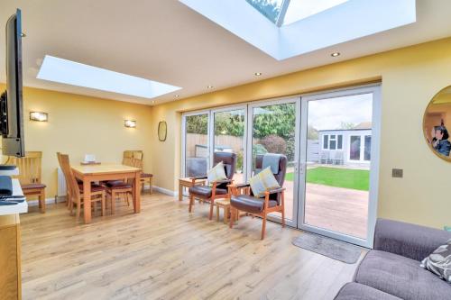 uma sala de estar com um sofá, uma mesa e cadeiras em Beautiful bungalow with parking and large garden em Southend-on-Sea