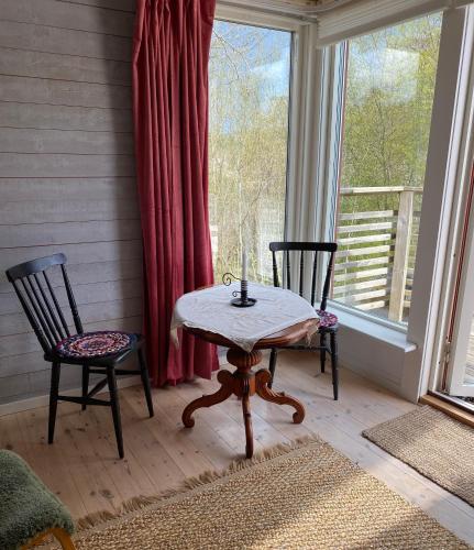 einen Tisch und zwei Stühle in einem Zimmer mit Fenster in der Unterkunft Sigridsro in Alingsås