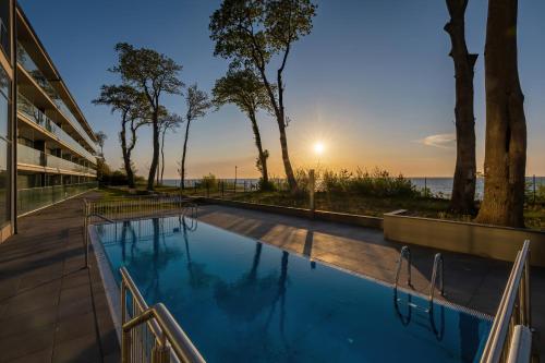 a swimming pool with a view of the ocean at HS Apartamenty Hevenia Heaven widok na morze in Rewal