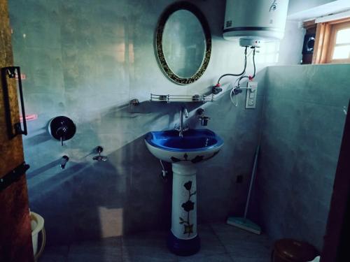 y baño con lavabo azul y espejo. en The Posh Residency, en Pahalgām