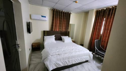 sypialnia z dużym łóżkiem z białą pościelą w obiekcie Ceetran Hotels w mieście Port Harcourt