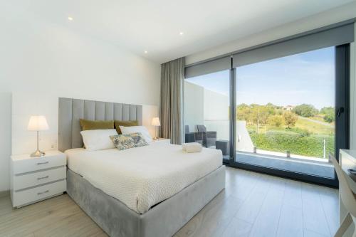 a bedroom with a bed and a large window at Quinta Solar da Portela in Almodôvar