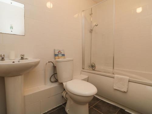 La salle de bains blanche est pourvue de toilettes et d'un lavabo. dans l'établissement Valley Lodge 44, à Callington