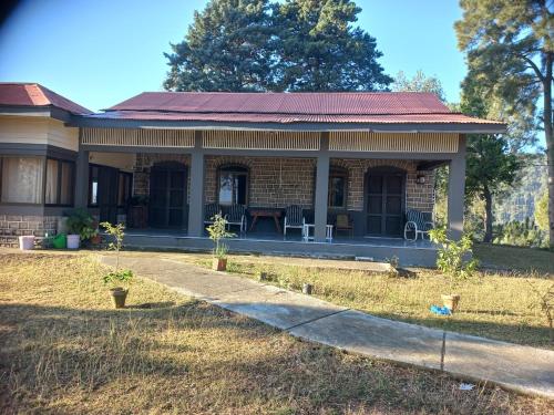 a small brick house with a sidewalk in front of it at Batrasi Dak Bungalow in Uttar Shisha