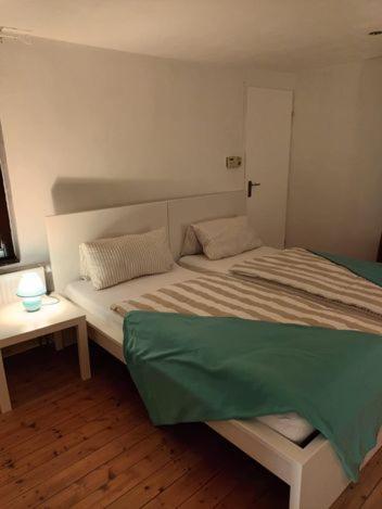 Un dormitorio con una cama con una manta verde. en Ferienhaus Valler, en Vallendar