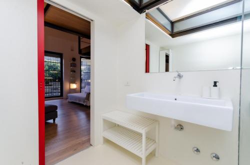 W łazience znajduje się biała umywalka i lustro. w obiekcie Esclusivo loft con due camere da letto e terrazzo w Mediolanie