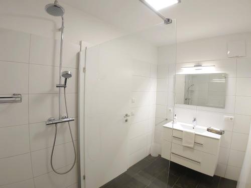 baño blanco con ducha y lavamanos en KitzviewTerrace, en Zell am See