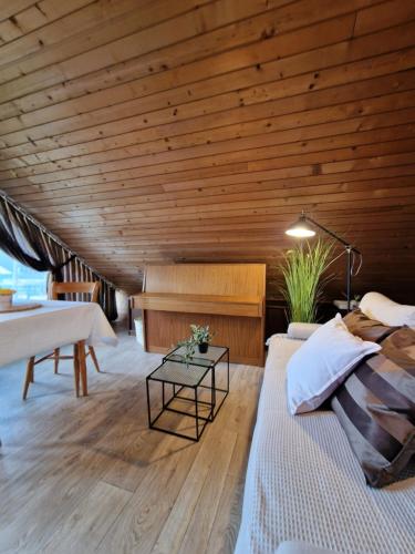 een slaapkamer met een houten plafond, een bed en een piano bij Vila Nana Bled Apartments & Rooms in Bled