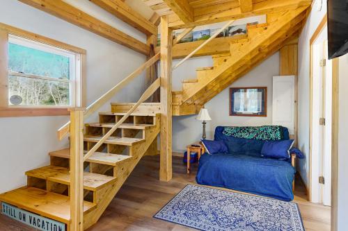 a spiral staircase in a tiny house with a blue couch at Cooper Cottage in Boothbay Harbor