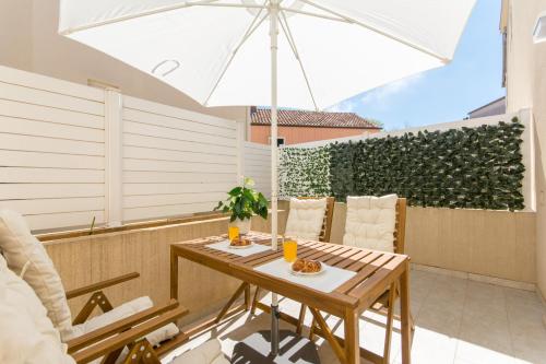 een patio met een tafel en een parasol bij Apartments D&D in Dubrovnik