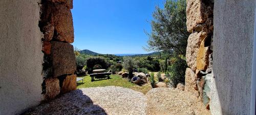 une vue depuis une fenêtre en pierre d'une cour avec des animaux dans l'établissement Bergerie A Sapara, à Pianottoli-Caldarello