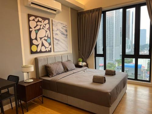 a bedroom with a large bed with a large window at Sentral Suites Kl Sentral By Luxe Home in Kuala Lumpur