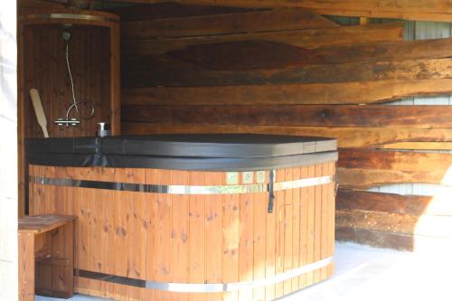 a wooden cabin with a hot tub in it at Chambre d'hôtes Les Cinq Mésanges 