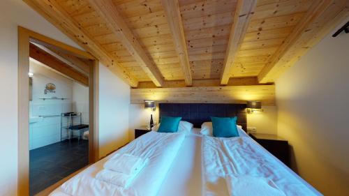 a bedroom with a large bed with a wooden ceiling at Apart-Chalet Kitzblick in Zell am See