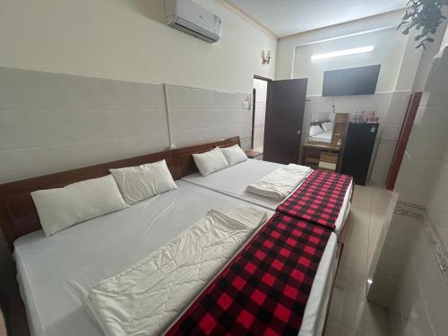 a bedroom with a bed with a checkered blanket at HOTEL ANH TUẤN in Ấp Cái Giá