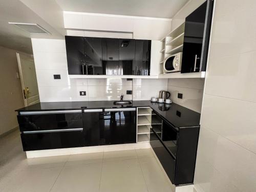 a kitchen with black and white cabinets and a sink at Cyan Recoleta Hotel in Buenos Aires