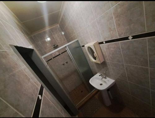een kleine badkamer met een wastafel en een spiegel bij Nikita Portuguese Restaurant and Motel in Lanseria
