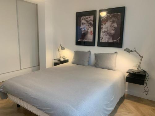 1 dormitorio con 1 cama blanca y 2 cuadros en la pared en House of Maximus - High standing - Centre 90m2 en Torremolinos