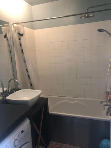 ein Badezimmer mit einem Waschbecken und einer Badewanne in der Unterkunft Appartement idéal JO in Maisons-Laffitte