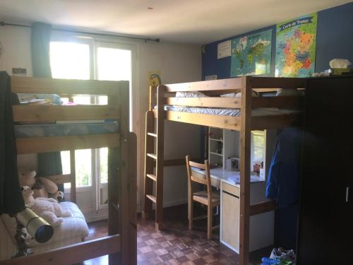 une chambre avec deux lits superposés et un bureau dans l'établissement Appartement idéal JO, à Maisons-Laffitte